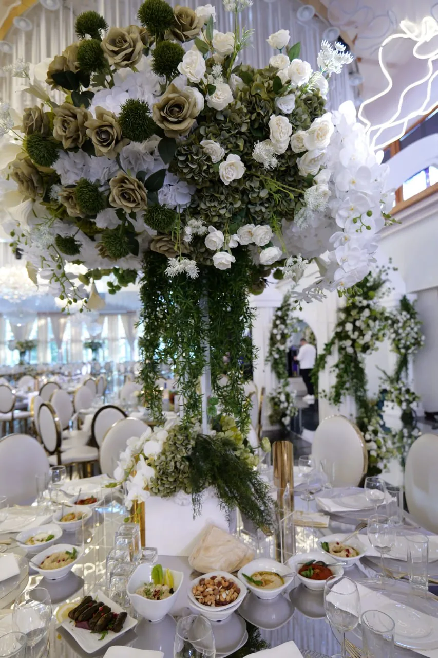 Högt blomsterarrangemang med vita och gröna blommor