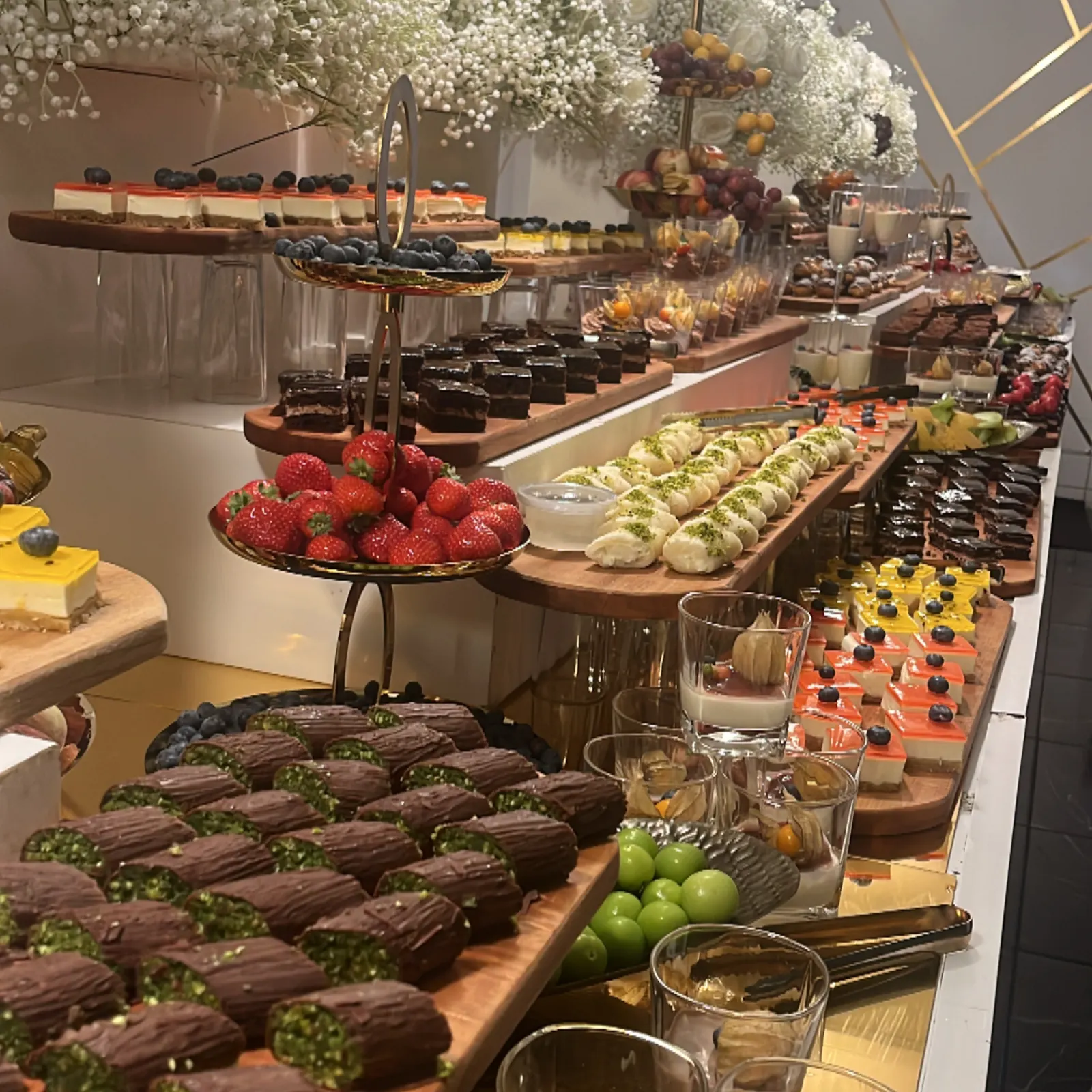 Dessertbord med bakelser, frukt och blommor